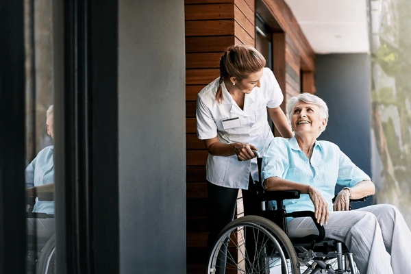 nurse-talking-senior-woman-on-wheelchair-600nw-2472675017